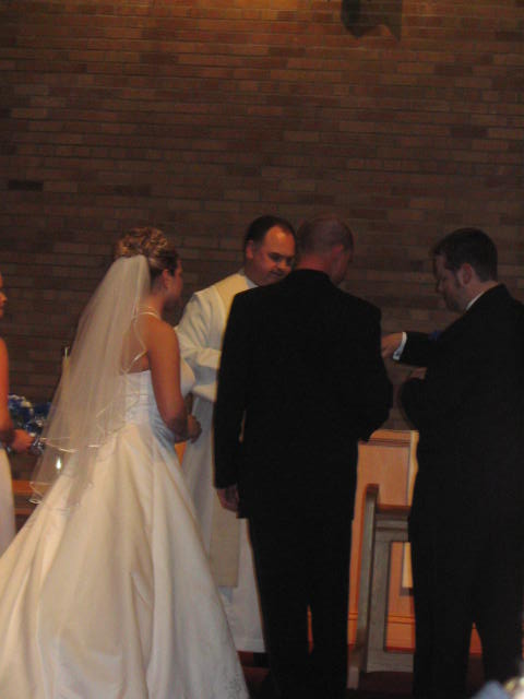 Grooms man with the bride and groom at the altar