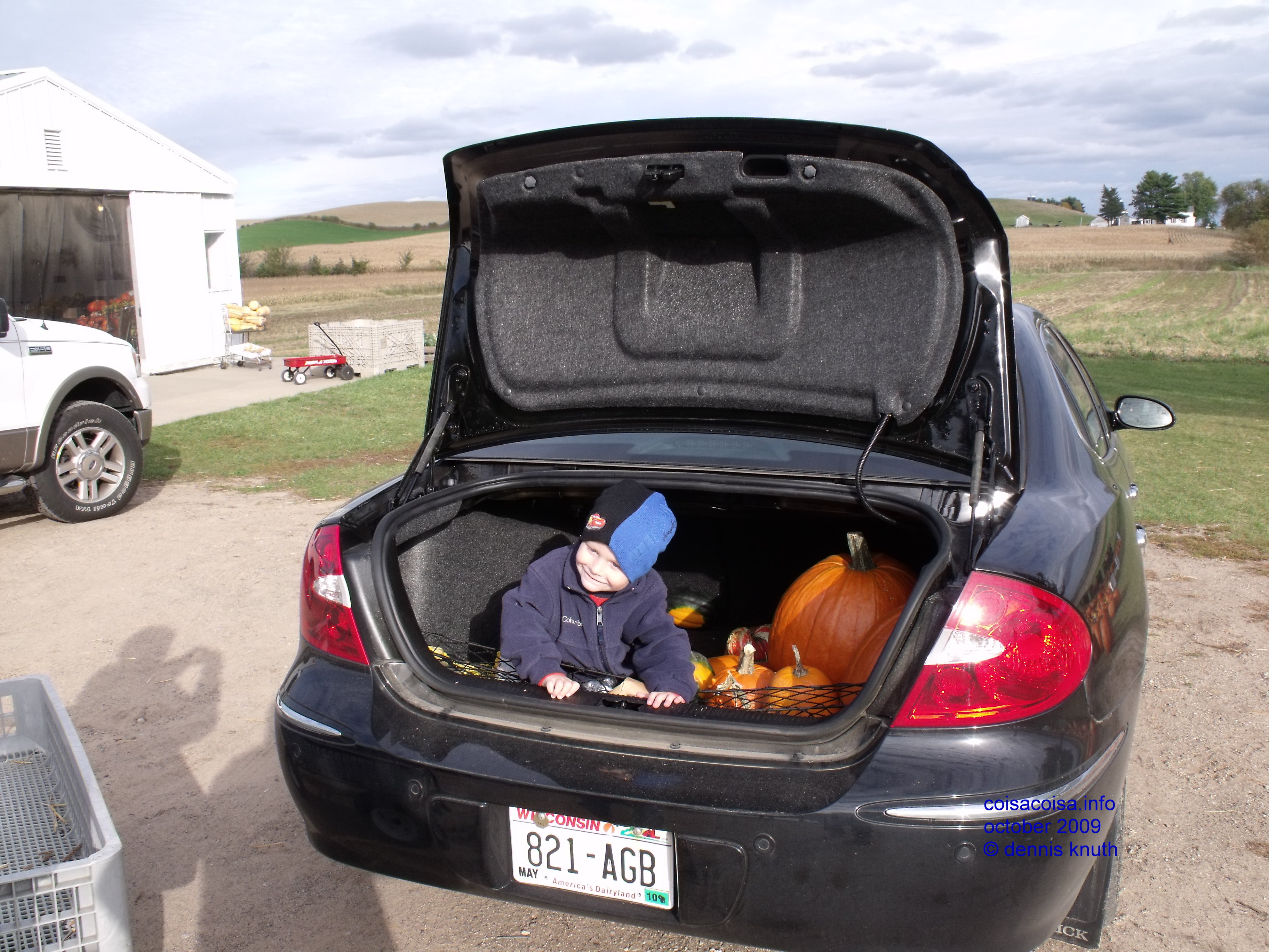 Jared loads the pumpkins picked into the car trunk