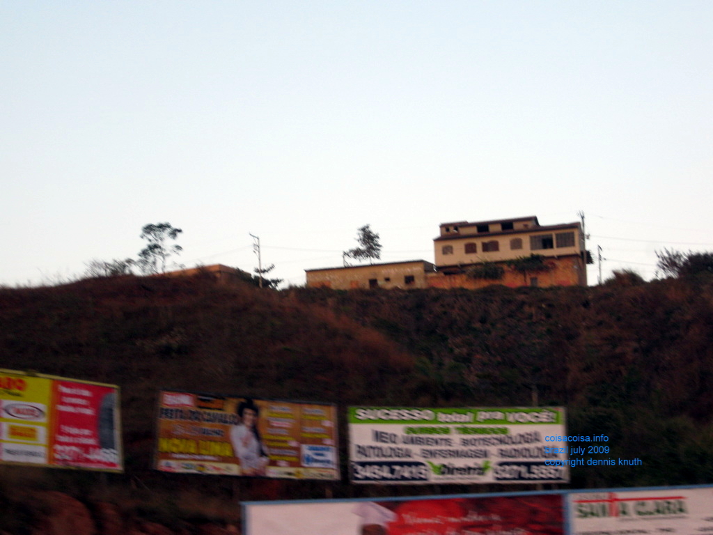 Bill boards and a home on a hill