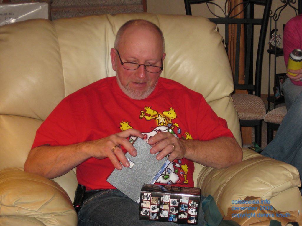 Gary works hard on opening a gift