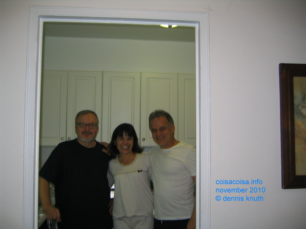 Dennis, Ines, Tarcisio framed by the kitchen door frame