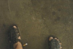 Man's feet in sandals on a dirty floor
